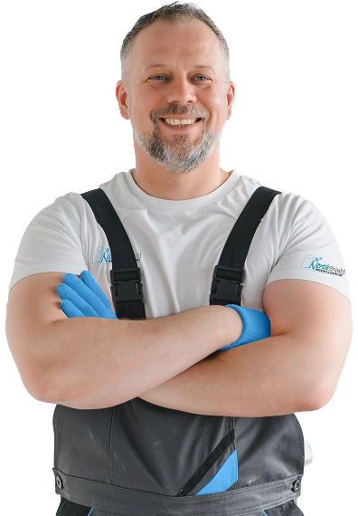 northshield man wearing blue gloves and overalls stands